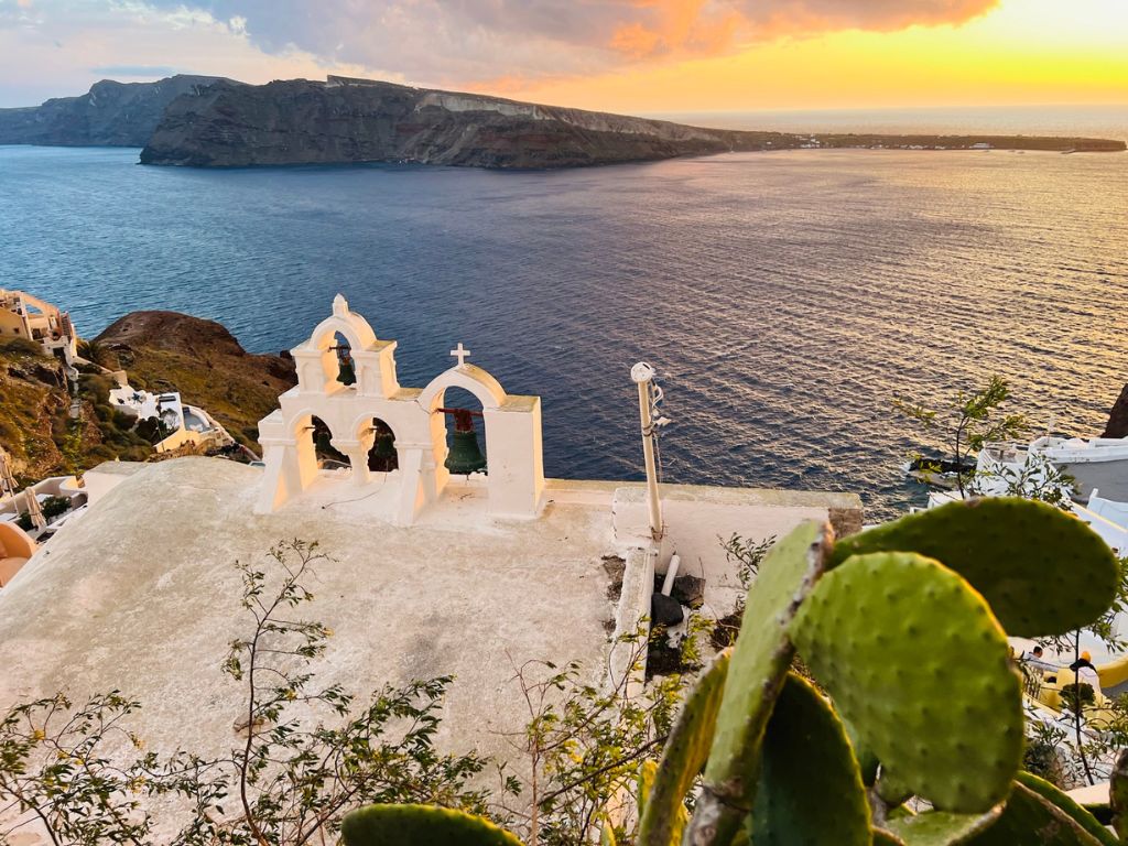 Oia village Santorini caldera view at sunset with blue domes