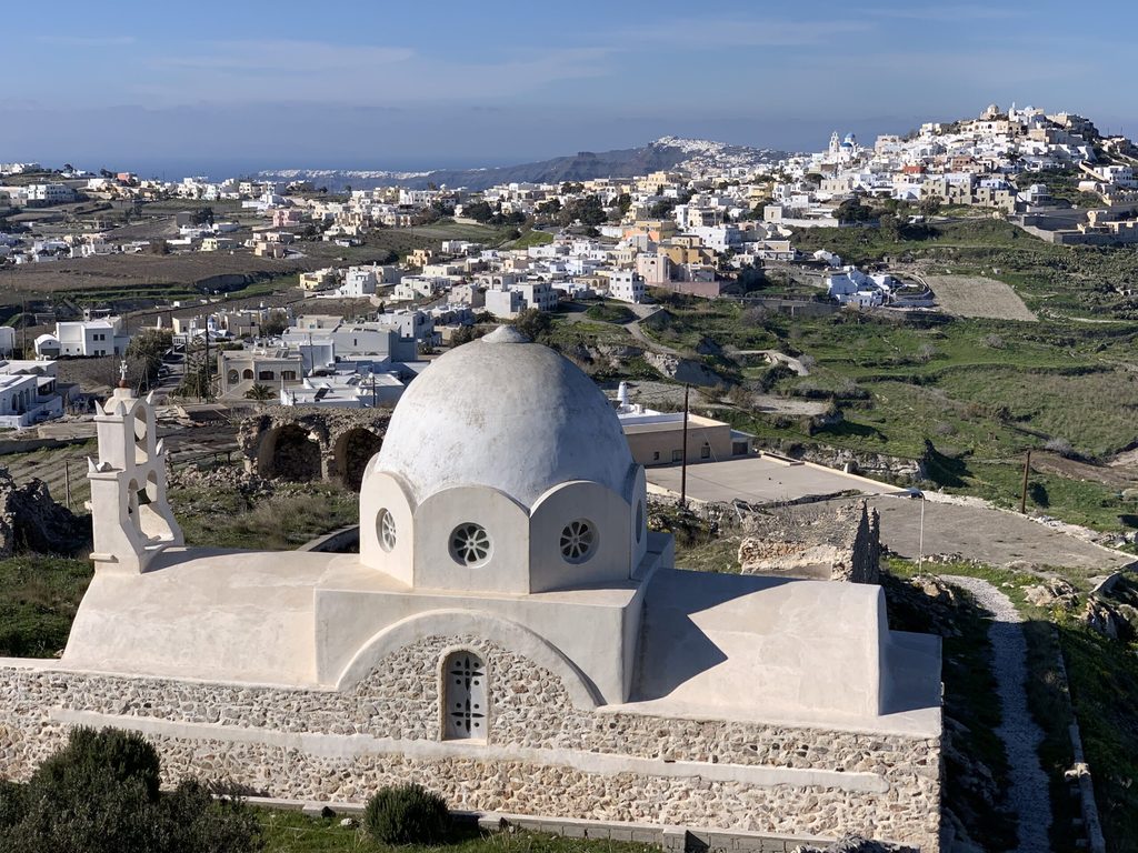 A restored chapel dome in the foreground with Pyrgos village on the hill behind, central Santorini